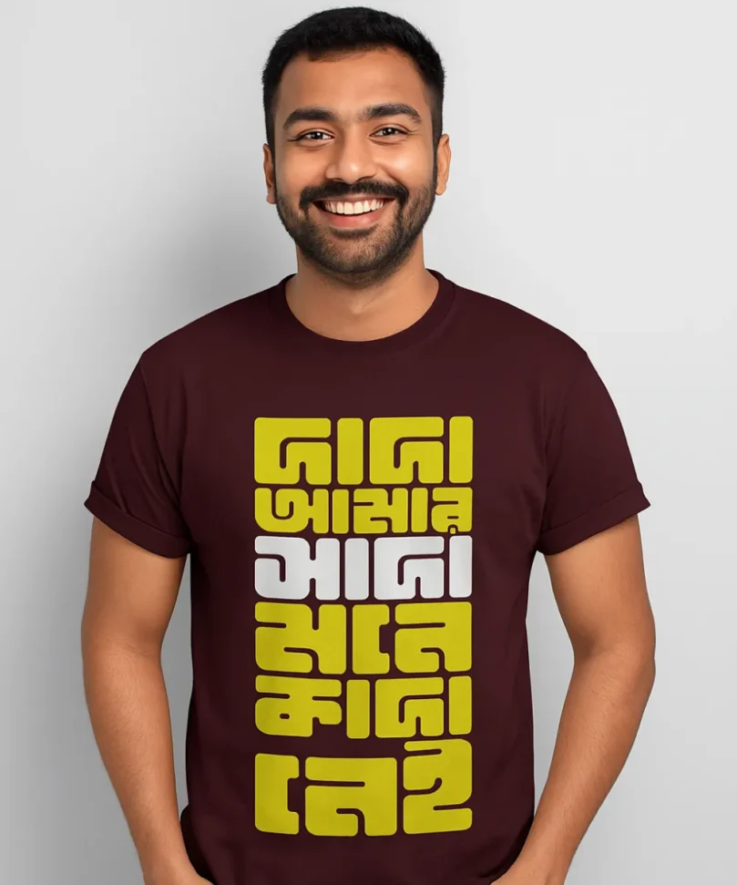 A model wearing a Bengali unisex t-shirt in Maroon color that says - Dada, amar sada mone kada nei