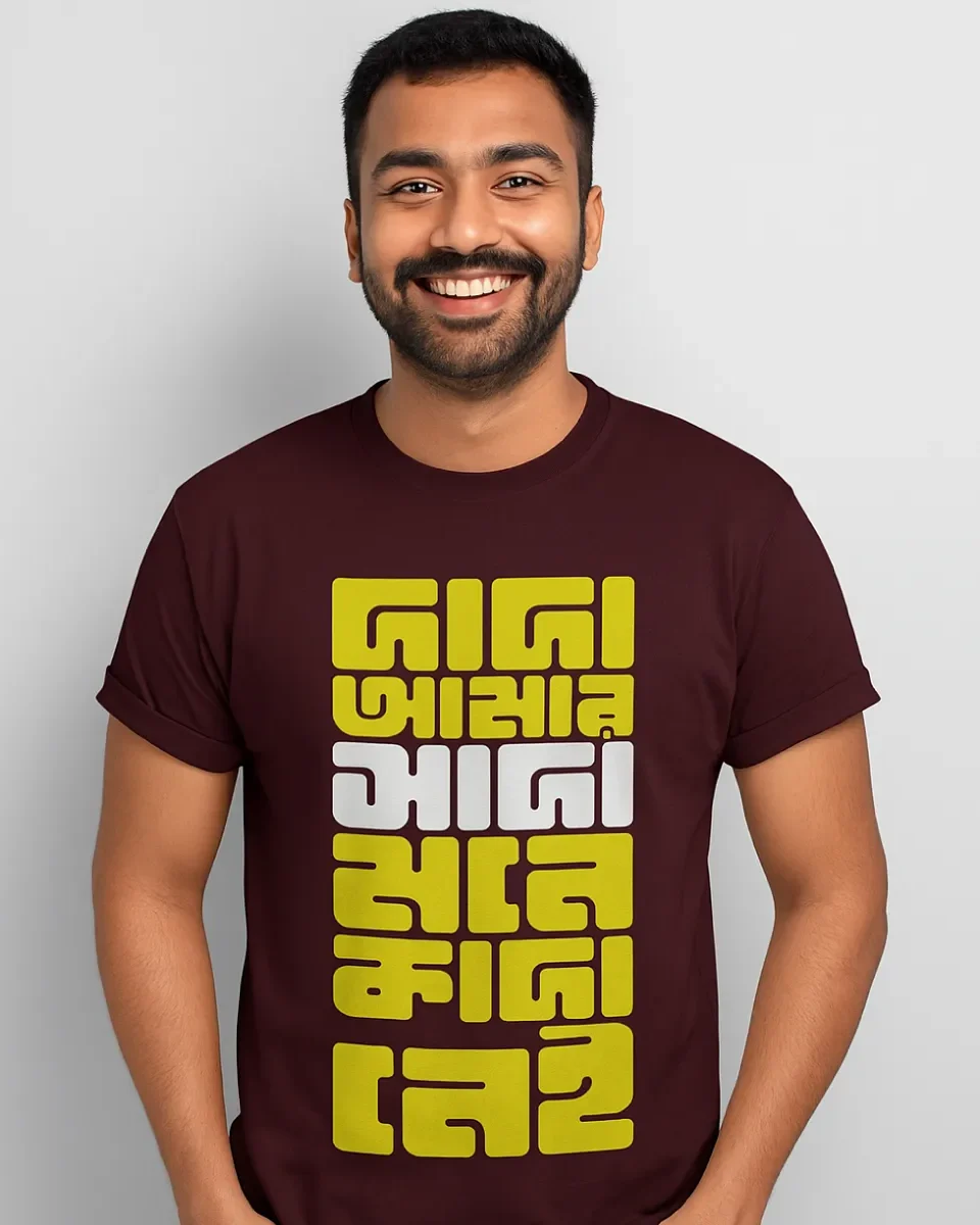 A model wearing a Bengali unisex t-shirt in Maroon color that says - Dada, amar sada mone kada nei